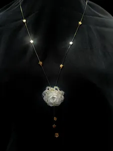 Gold-toned lariat-style necklace with a flower pendant and bead accents.